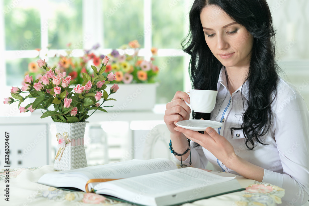 Portrait of beautiful young woman sitting at table Portrait of beautiful young woman sitting at table