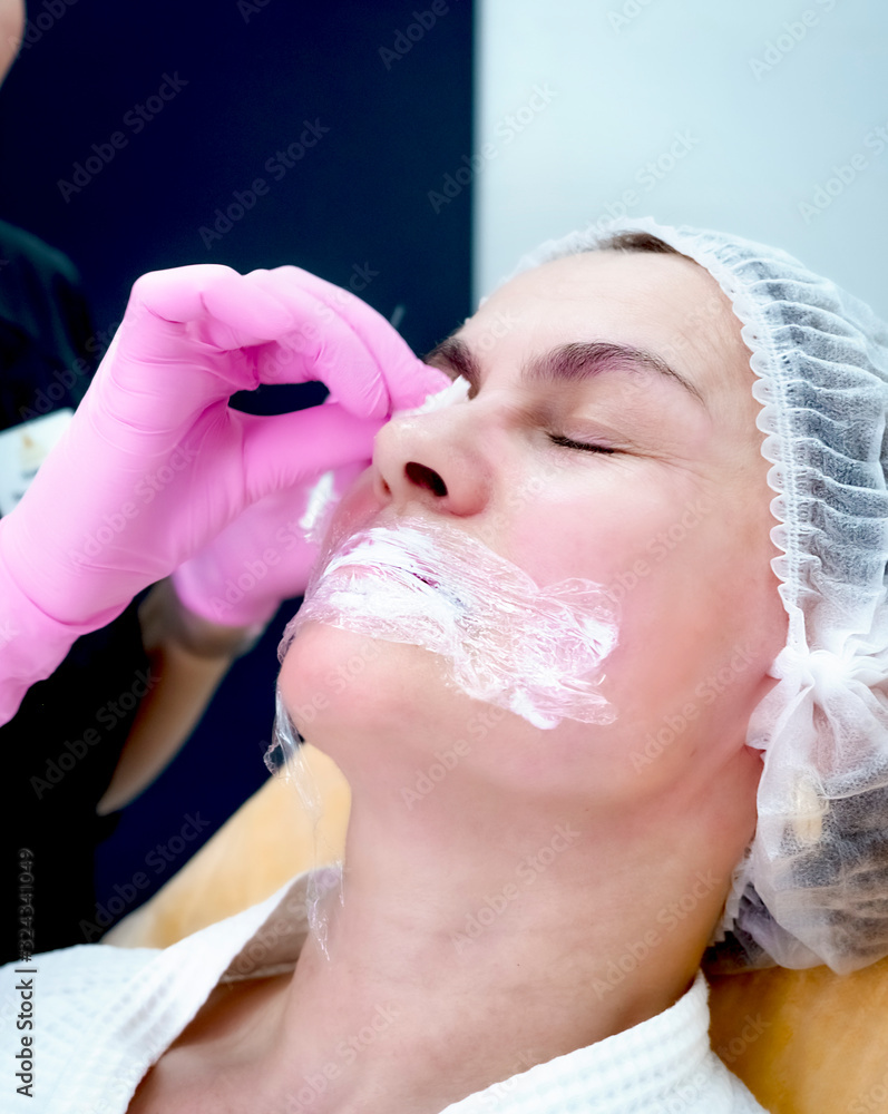 Woman getting botox injection in spa. contour plastic. A cosmetologist injects a botulinum toxin to tighten and smooth out wrinkles on the skin of a female face