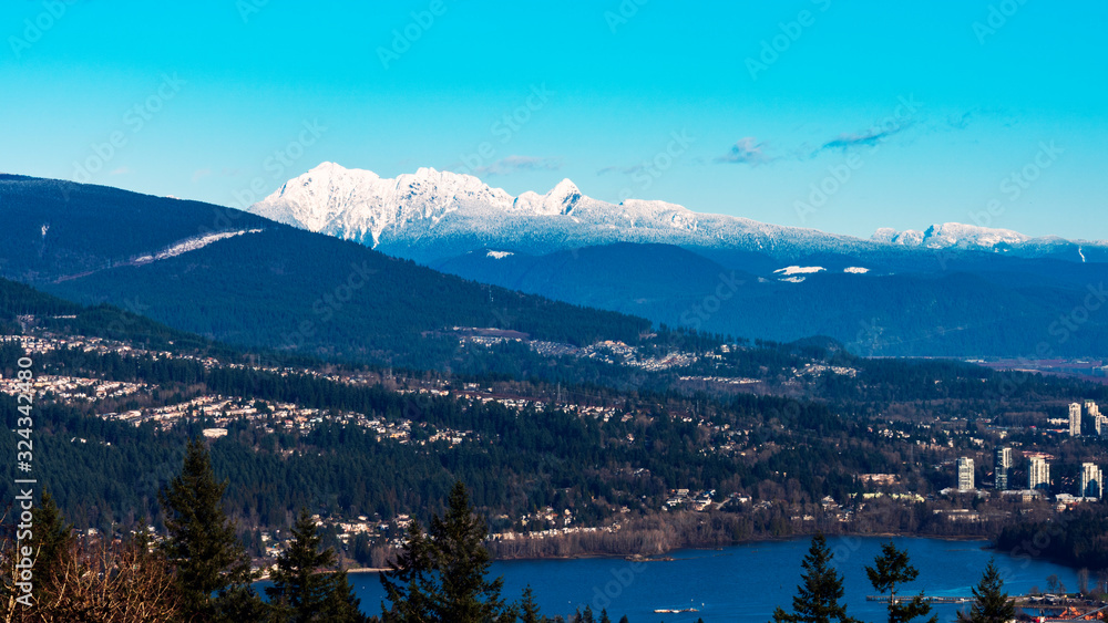View across Burrard Inlet and Port Moody to snow-covered mountains on horizon