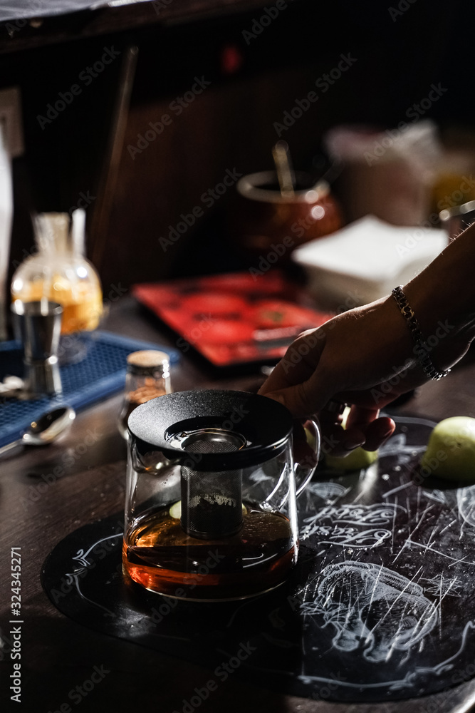 Fototapeta premium bartender makes original tea with cinnamon and apples