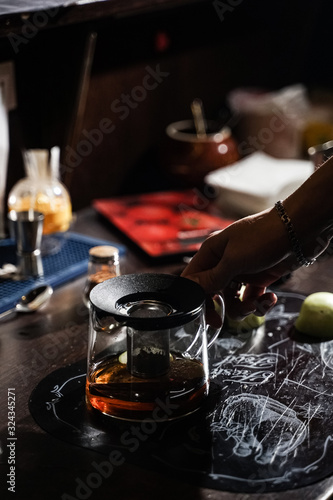 bartender makes original tea with cinnamon and apples