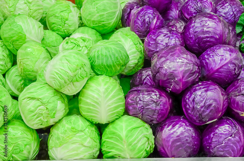 Assortment of organic red and green cabbage heads close-up at farmer market