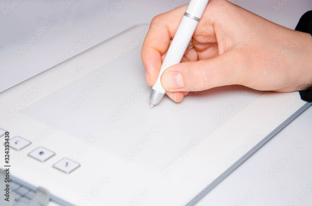 female-hands-work-on-a-graphic-tablet-hand-holds-stylus-pen-and-draws