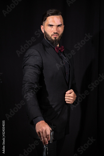 Stylish bearded man with cane in studio