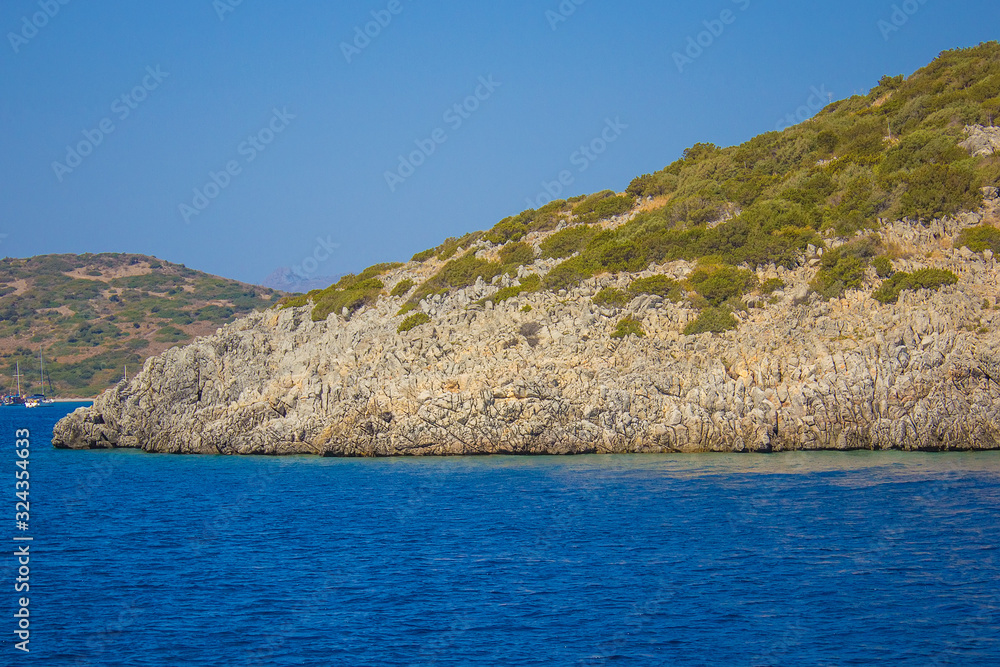 Sharp stones and rocks in the clear blue water of Aegean sea near the shores of Bodrum city, Mugla. Beautiful Turkish seascape. Aegean coast in Turkey. Travel concept. Water activity