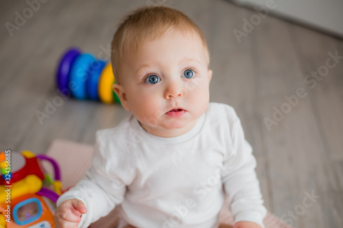 baby is sitting on the floor playing with educational toys