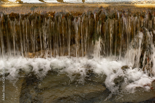 Wasserstau am Bach mit Überlauf Wasserfall Schaum