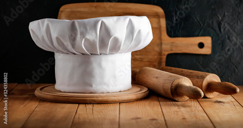 Cook hat on wooden desk and free space for your decoration. 