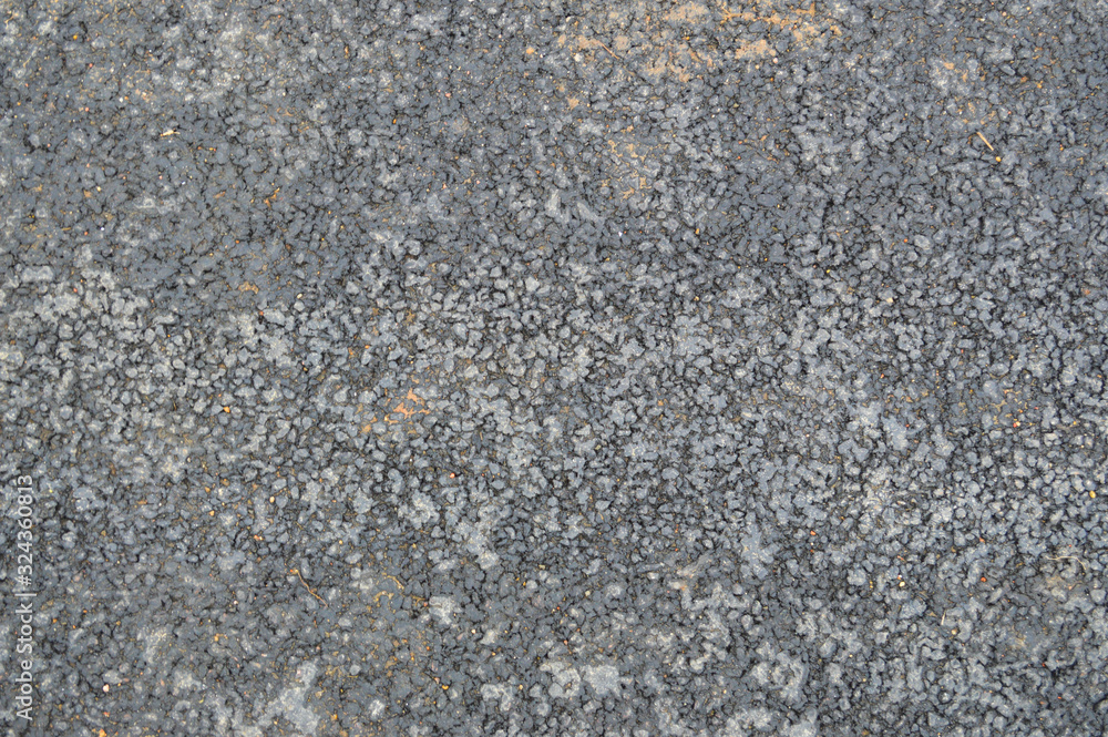 Gray asphalt road with small pebbles and cracks. Texture, background Gray asphalt road with small pebbles and cracks. Texture, background