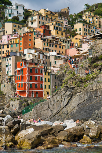 Obraz na płótnie Riomaggiore, Cinque Terre, Italy - August 17, 2019: Village by the sea bay, colorful houses on the rocky coast. The protected area of ​​the mountains. A popular resort in Europe w salonie