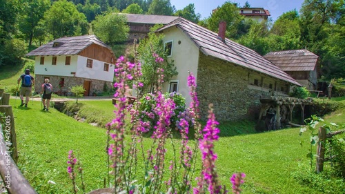 A man and woman visit the old mill at Prevalje, Slovenia, on a sunny afternoon photo