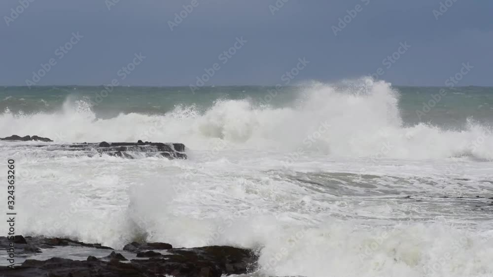Large waves crashing into the rocky point between Porpoise Bay and Curio Bay on the Catins coast, Otago, New Zealand. Large waves crashing into the rocky point between Porpoise Bay and Curio Bay on the Catins coast, Otago, New Zealand.