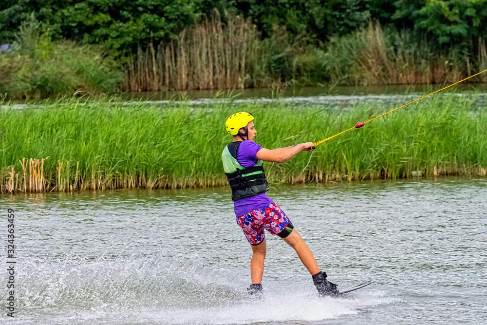Teenager wakeboarding on a lake - Brwinow, Masovia, Poland Teenager wakeboarding on a lake - Brwinow, Masovia, Poland