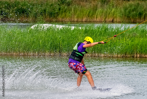 Fototapeta Naklejka Na Ścianę i Meble -  Teenager wakeboarding on a lake - Brwinow, Masovia, Poland