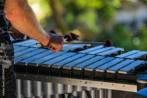 Tableau sur toile A close up and rear view of a folk musician playing a vibraphone on stage at a m
