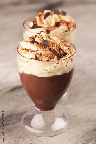Hot chocolate cocoa in glas cup with whipped cream on vintage background