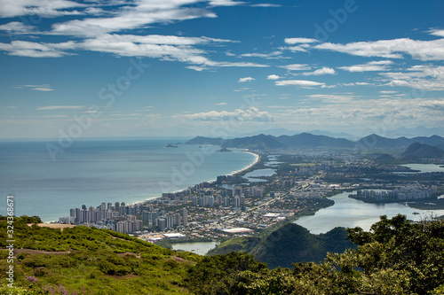 Coastal neighbourhood Barra da Tijuca in Rio de Janeiro, Brazil, seen from a high vantage point with high rise luxury buildings in the foreground, mountains and swamp land lakes in the background photo