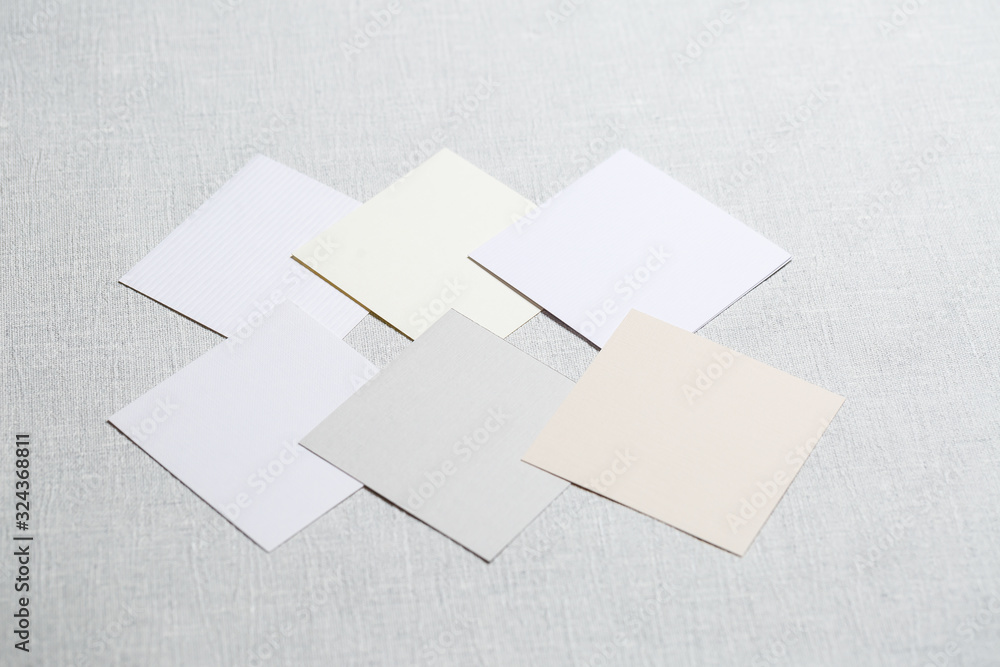 square pieces of multi-colored fabric laid out on a gray background square pieces of multi-colored fabric laid out on a gray background