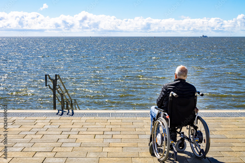 Obraz premium Rollstuhlfahrer am Meer 