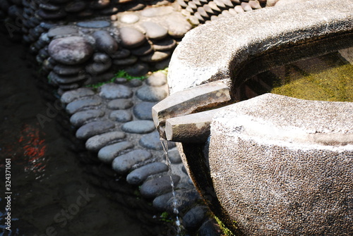石造りの手水鉢と流れる水