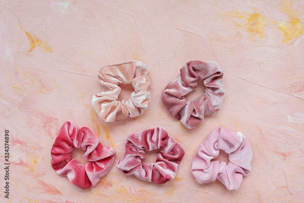 Collection of trendy velvet scrunchies on pink background. Diy accessories and hairstyles concept, copy space