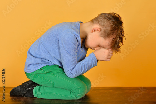 Принти на полотні The boy bowed in prayer before God