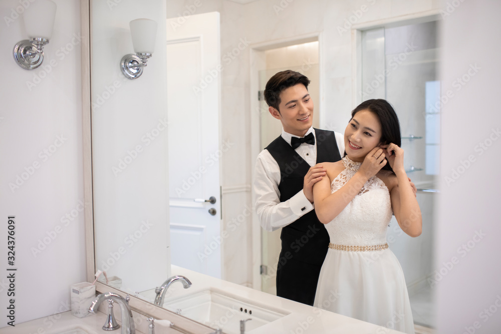 Happy young Chinese couple getting dressed in bathroom Happy young Chinese couple getting dressed in bathroom