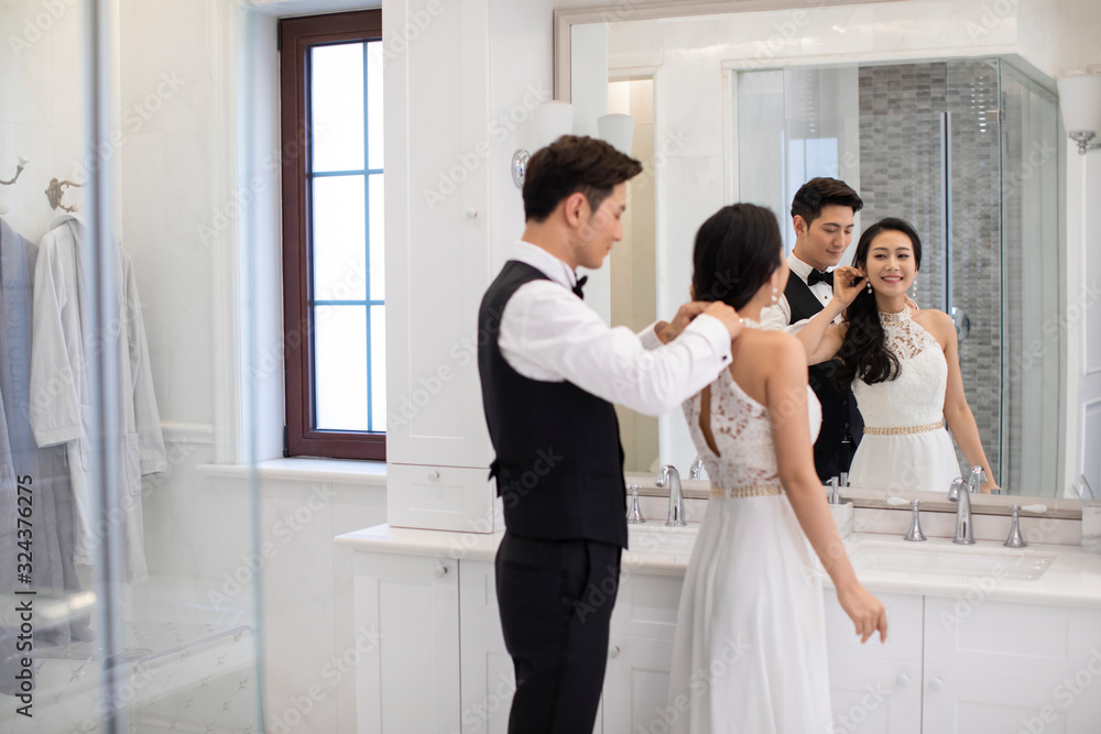 Happy young Chinese couple getting dressed in bathroom Happy young Chinese couple getting dressed in bathroom