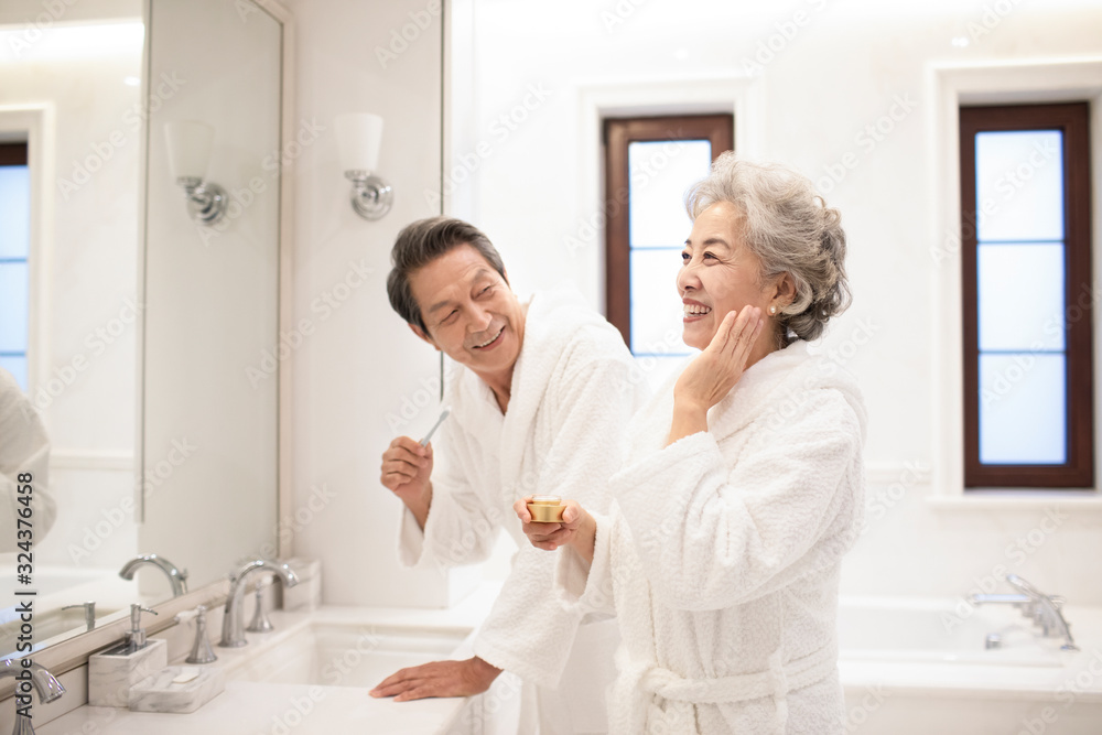Happy senior Chinese couple going through their morning routine in bathroom Happy senior Chinese couple going through their morning routine in bathroom