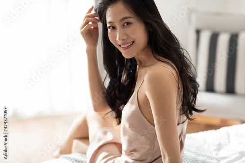 Happy young Chinese woman waking up in the morning