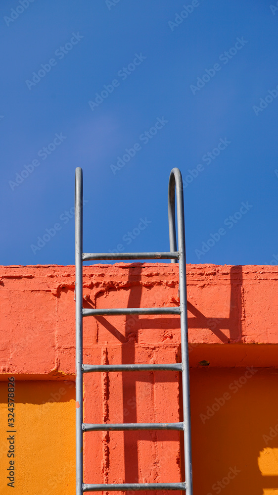 Fototapeta premium orange walls with stairs under the blue 