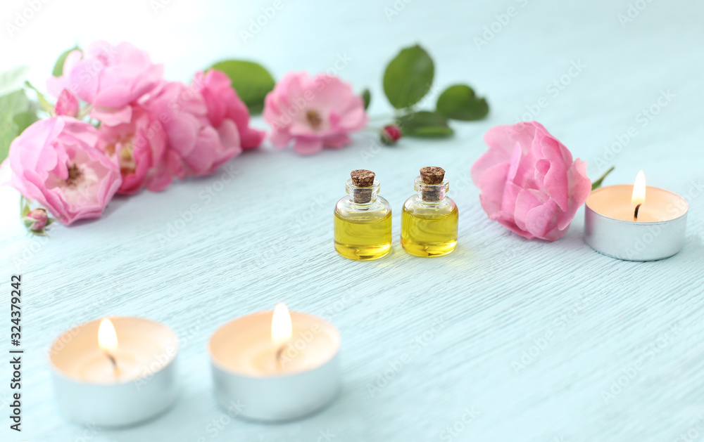 Rosehip cosmetic oil in mini bottles and pink rosehip flowers. Spa treatments for relaxation. Rosehip cosmetic oil in mini bottles and pink rosehip flowers. Spa treatments for relaxation.