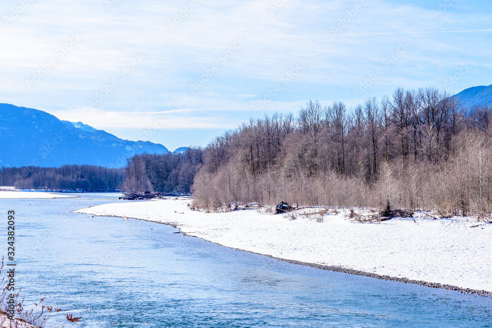 Majestic mountain river in winter over snow mountains and blue sky in Vancouver, Canada. Majestic mountain river in winter over snow mountains and blue sky in Vancouver, Canada.
