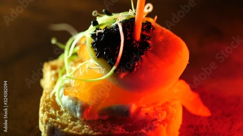 Tartlet Gourmet food close up appetizer. Canape made of Salmon, Egg and Lumpfish black Roe on bread. Macro dolly move.
