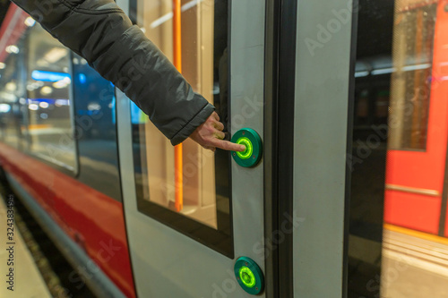 Frau drückt den Knopf für die Türöffnung bei einem Reisezug