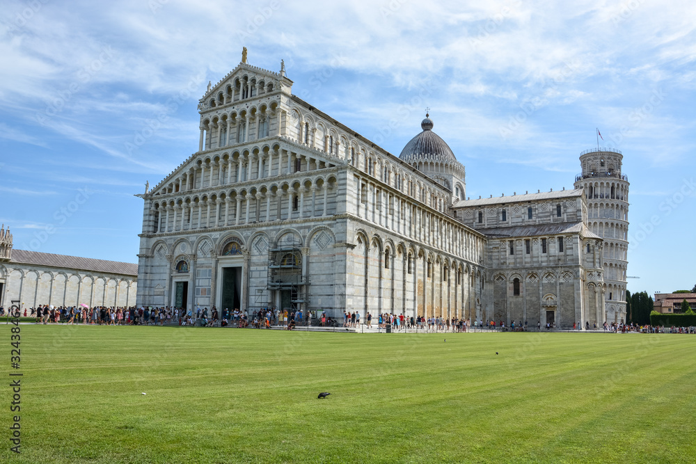 PISA, ITALY - August 14, 2019: The cathedral of Pisa near the leaning tower of Pisa with lots of tourists