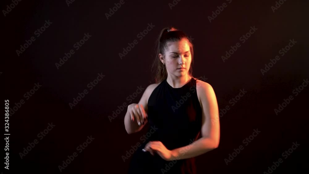 Girl on a black background dancing and stroking the thigh and snaps his hand Girl on a black background dancing and stroking the thigh and snaps his hand