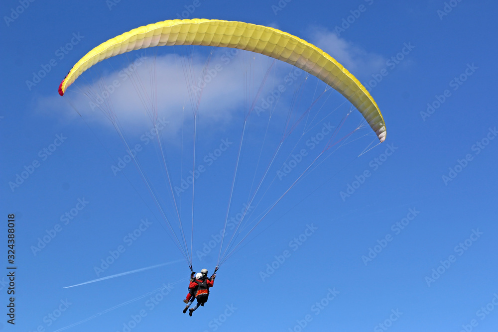 Tandem Paraglider flying wing in a blue sky	