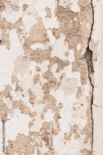 Big Crack on grungy weathered old concrete wall texture with white paint peeling