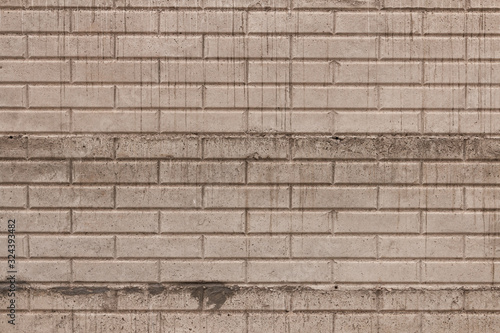 Old worn concrete wall texture with brick pattern in gray with cement dripping patterns