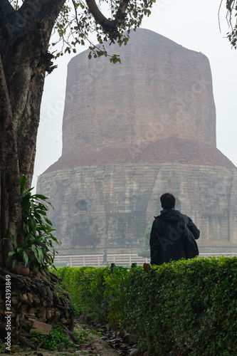 Tourist man at India stupa Dhamek, where Buddha gave his first speech, located at Sarnath near Varanasi. photo