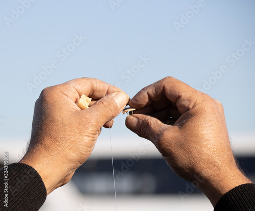 The man was photographed with both hands while placing the bait on the hook.