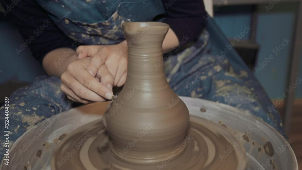Female artisan using a pottery wheel in her studio Female artisan using a pottery wheel in her studio