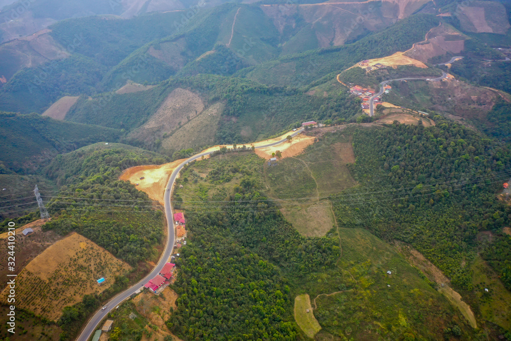 aerial scenic view of mountain road and rural village living along, in Laos. 