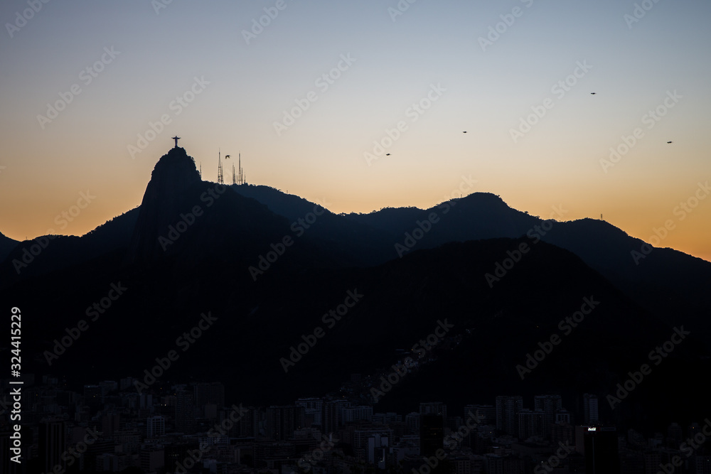 View of Christ the redeemer (Cristo Redentor) as a silhouette on top of Mount Corcovado just after sunset as nightfall begins in Rio de Janeiro, South America
