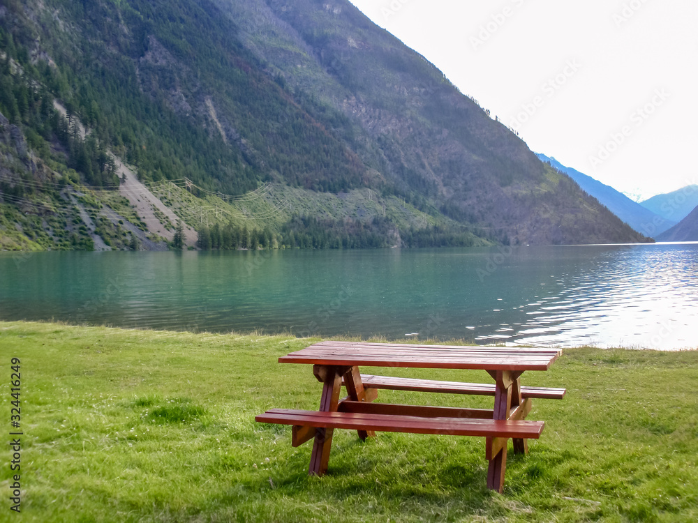 Picnic Table in Park with mountain lake background.