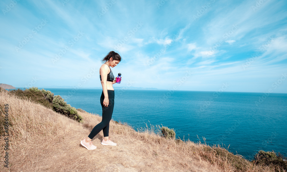 Sporty woman hiking on Makara beach, Wellington New Zealand Sporty woman hiking on Makara beach, Wellington New Zealand