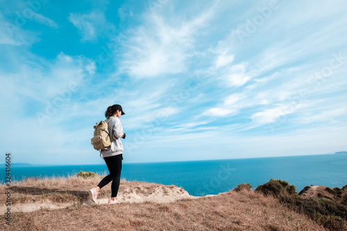 Woman photographer hiking on Makara beach  Wellington  NZ