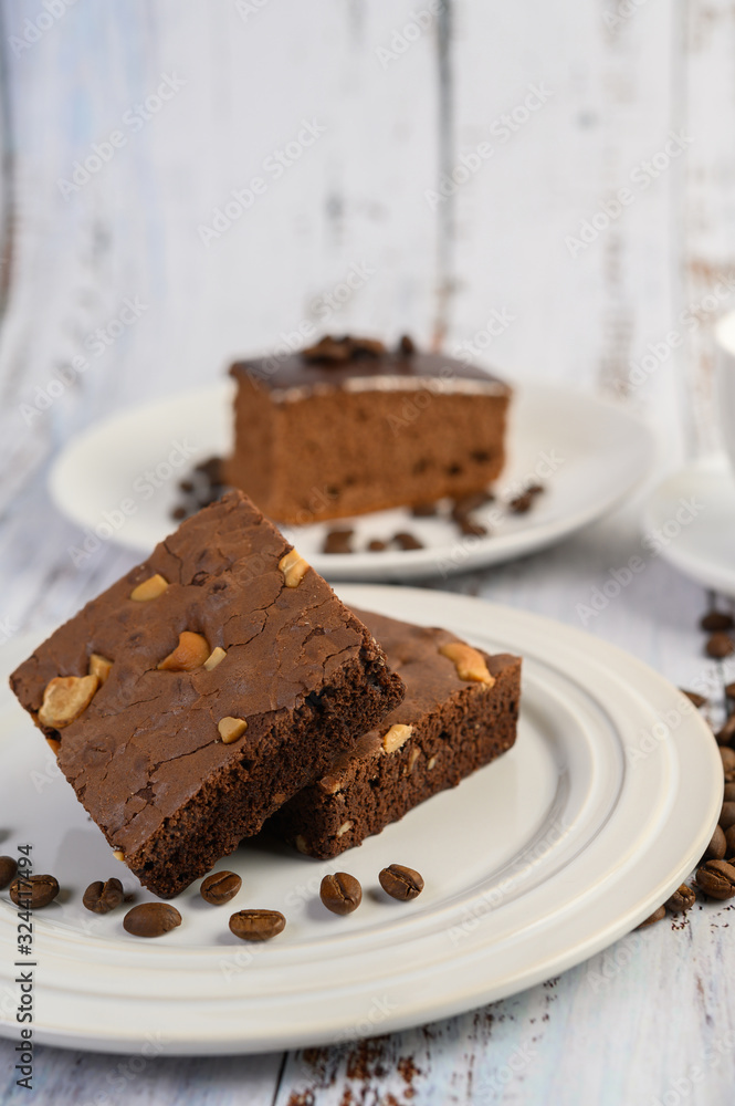 Chocolate brownies on a white plate and coffee beans. Chocolate brownies on a white plate and coffee beans.