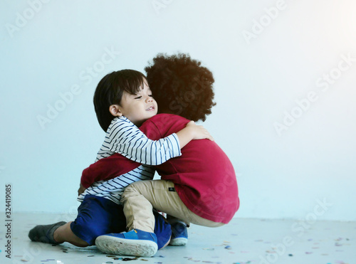 Two lovely little boy play and hugging together in school.